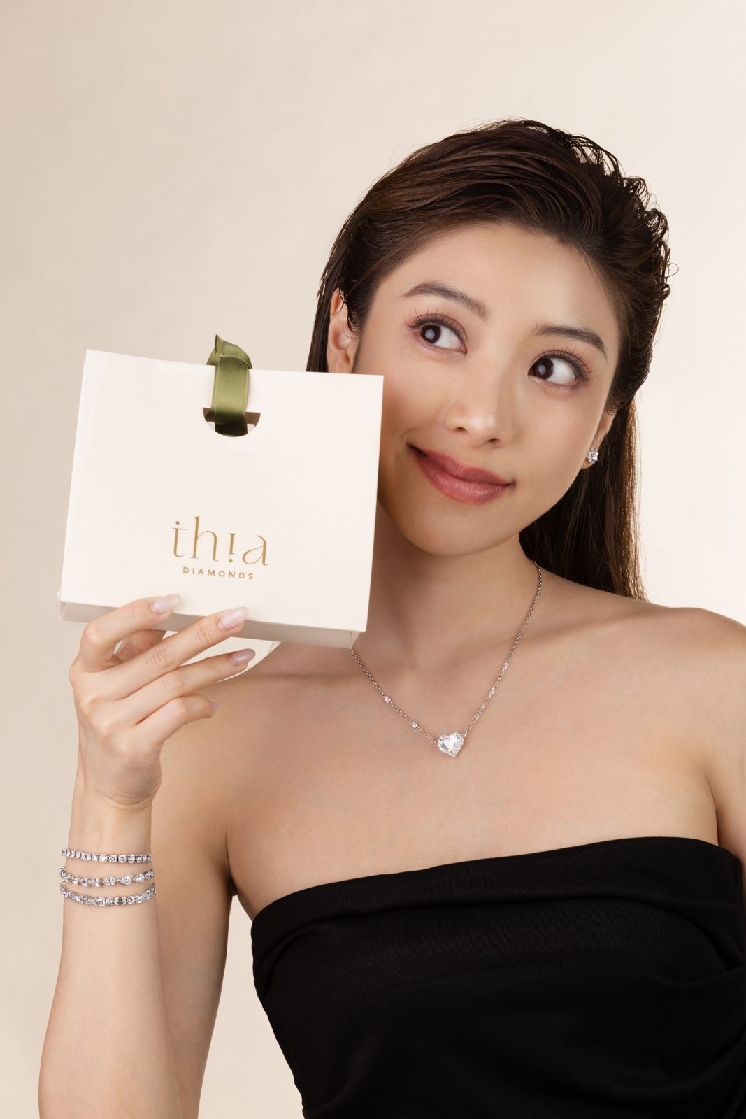 Model holding the cream thia Diamonds gift bag