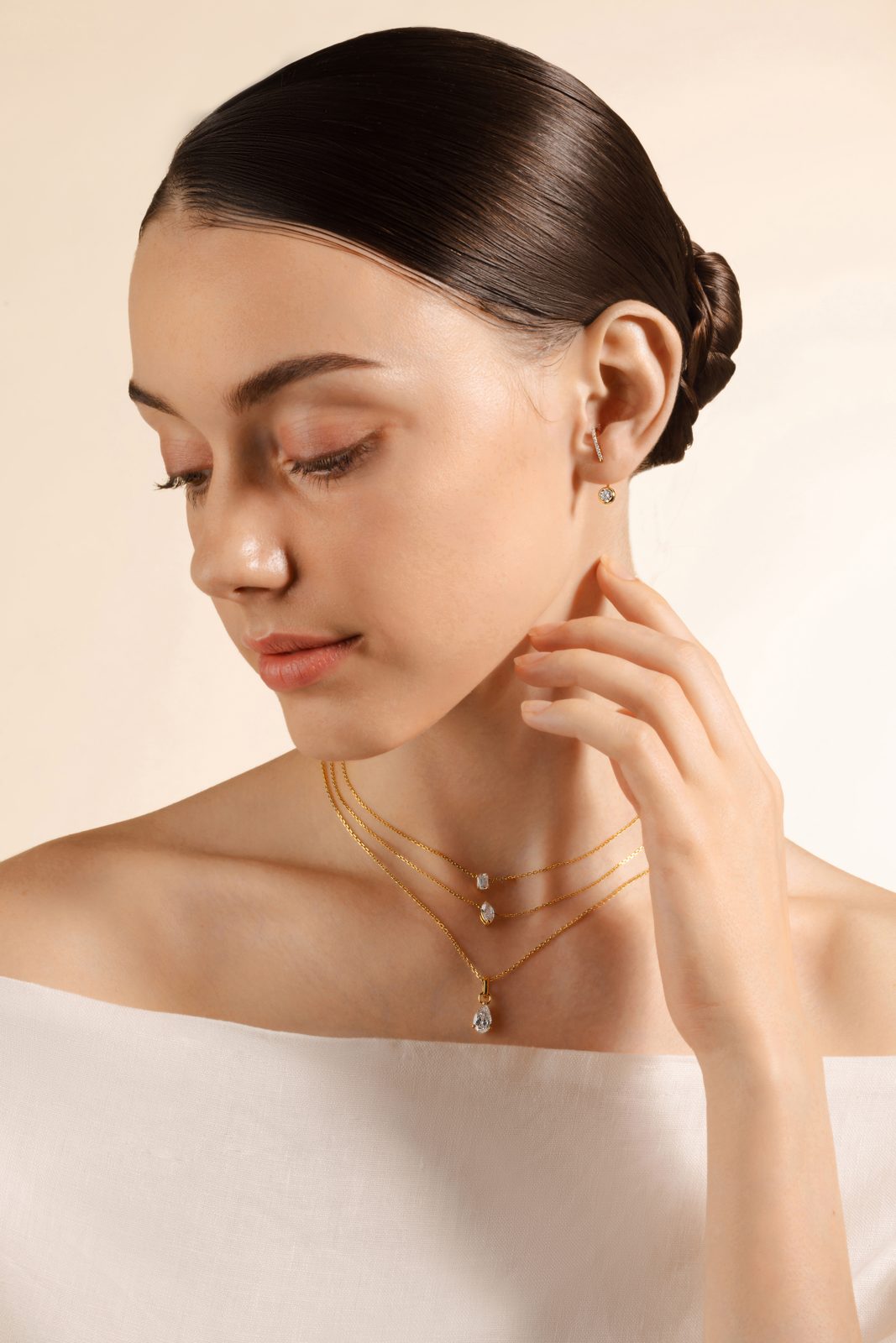 Model wearing layered gold Thia necklaces